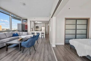 Een modern appartement met een woongedeelte, keuken en een balkon met uitzicht op de stad.