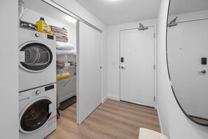 Un cuarto de lavandería con toallas apiladas, una lavadora y una secadora.