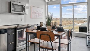 Una cocina moderna con comedor, ventanas amplias y vista al río.