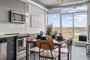 Una cocina moderna con comedor, ventanas amplias y vista al río.