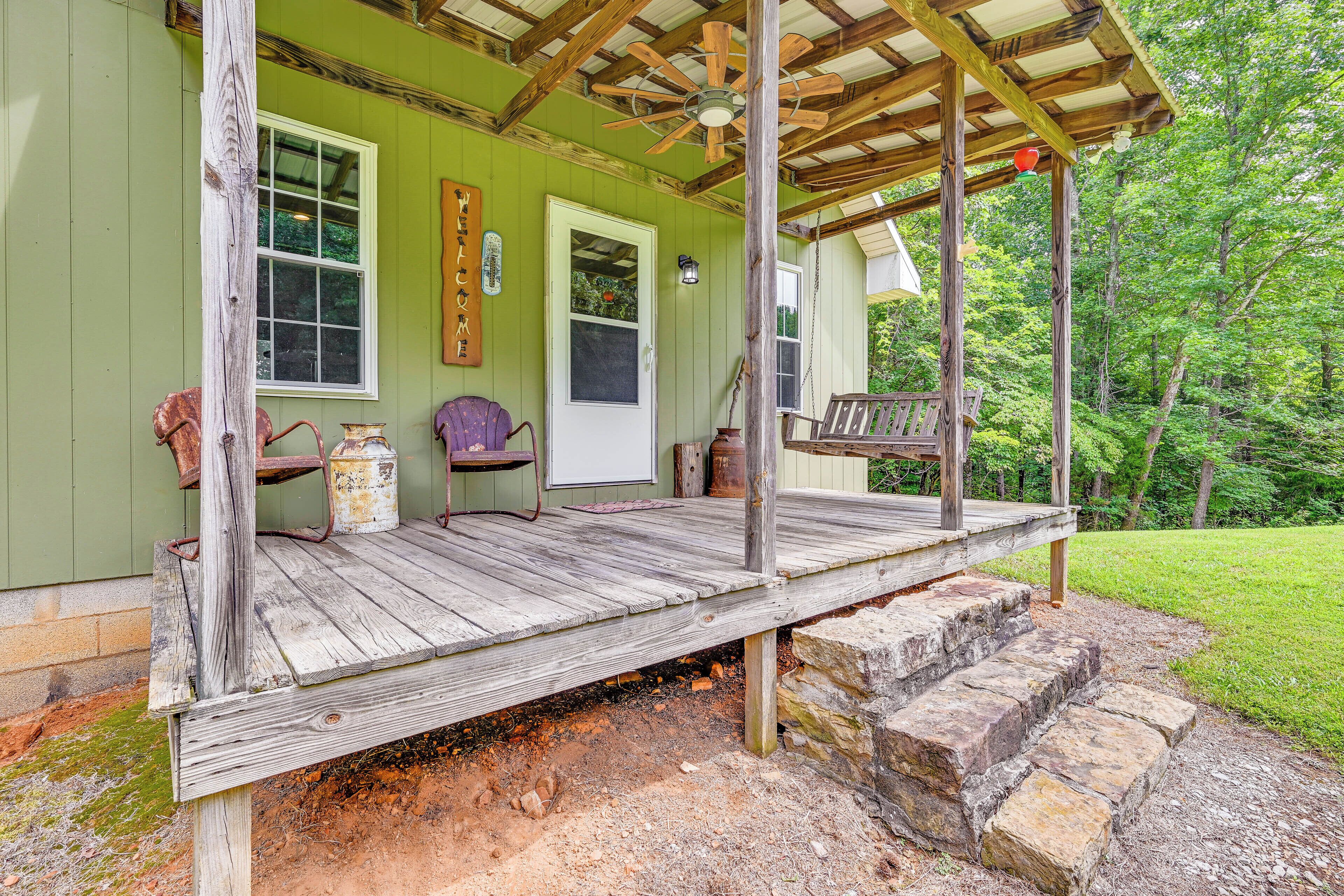 A wooden porch with a bench, a door, and a window.