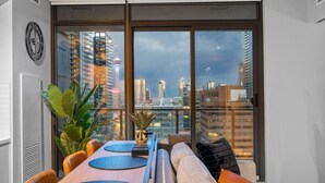 Un salon moderne avec une grande fenêtre, une horloge au mur et une vue sur le paysage urbain.