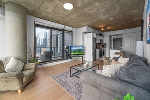 A modern living room with a sofa, a coffee table, and a TV.