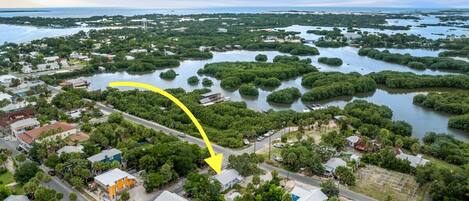 An aerial view of a coastal town with a prominent yellow arrow pointing to a specific area.