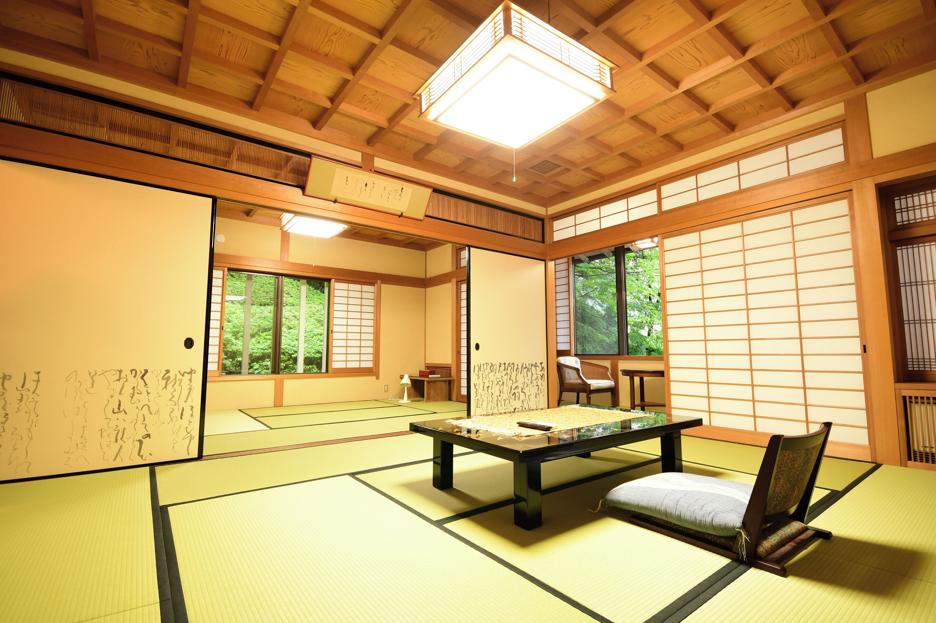 A traditional Japanese room with tatami flooring, a low table, and sliding doors.