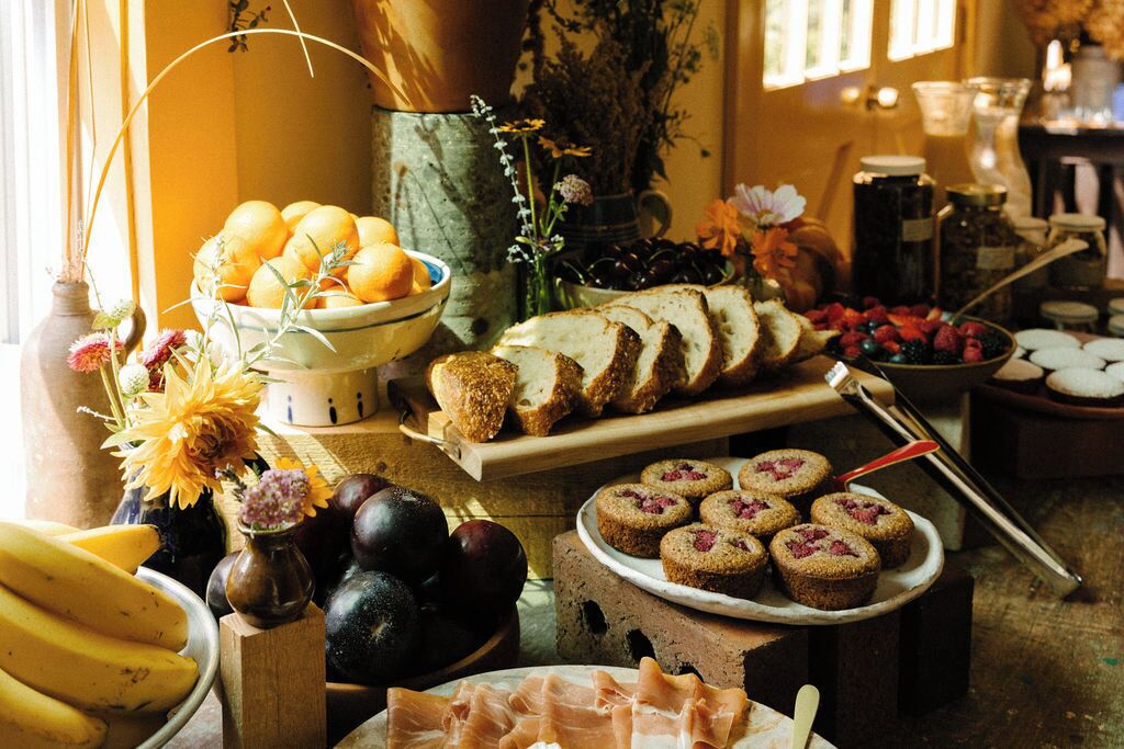 A table with various food items including bread, pastries, and fruits.
