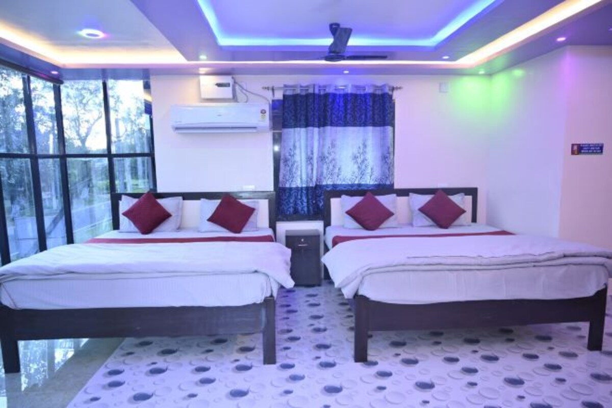 A hotel room with two beds, a window, and a ceiling fan.