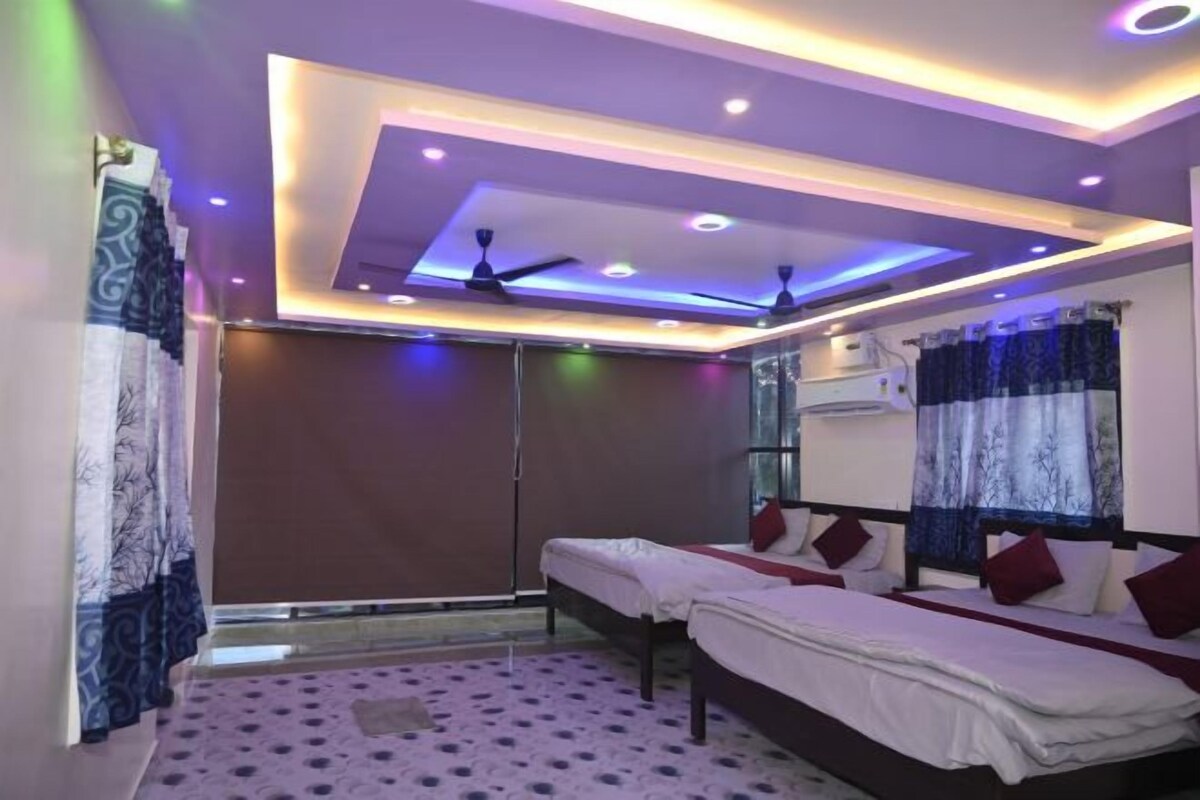 A bedroom with a bed, a window with curtains, a ceiling fan, and recessed lighting.