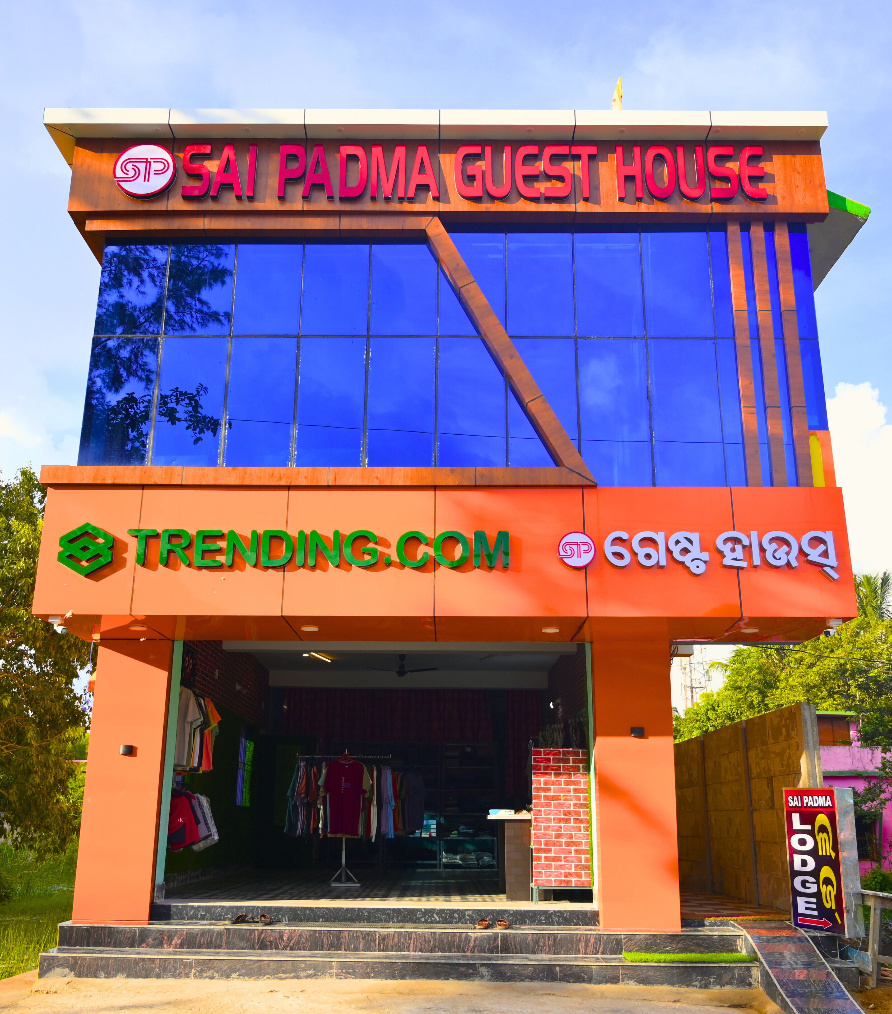 A building with a sign reading 'SAI PADMA GUEST HOUSE' and 'TRENDING.COM'.