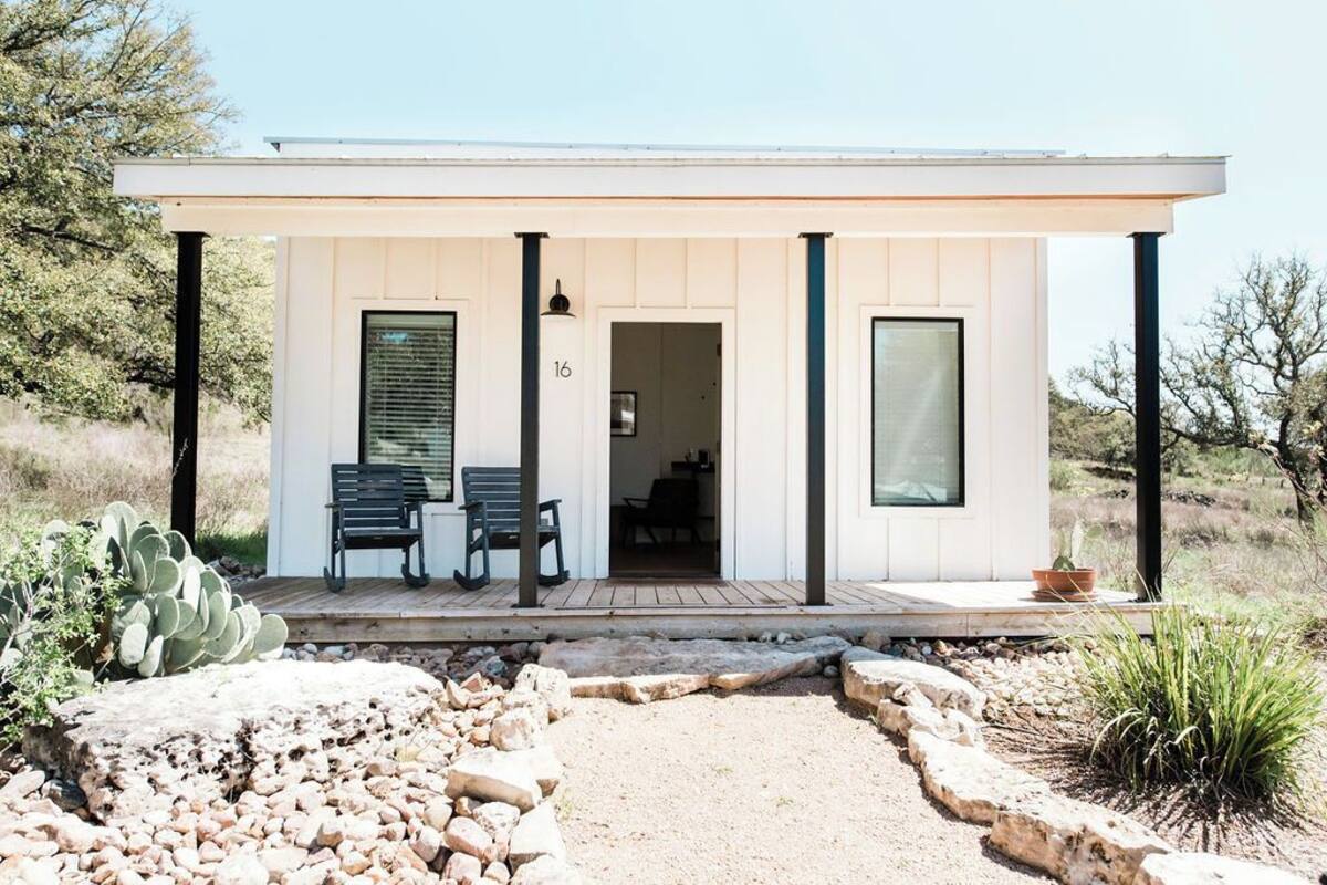 Un bâtiment moderne, de plain-pied, doté d’un porche abrité, du chiffre « 16 » peint sur le mur et d’un cactus au premier plan.