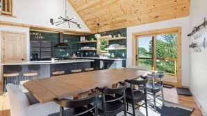 Een moderne keuken met een houten plafond, een centraal eiland en barstoelen.
