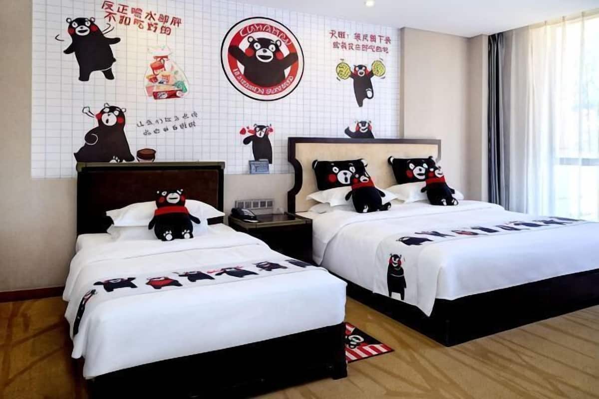 A hotel room with two beds, each with a bear-themed bedspread, a large wall clock, and a bear decoration.