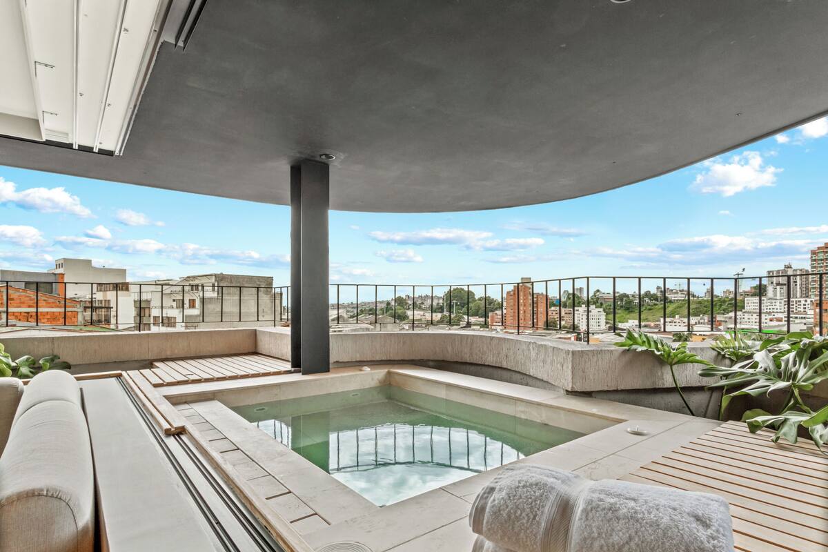 A rooftop terrace with a pool, lounge area, and city views.