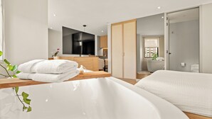 A modern bathroom with a bathtub, a toilet, and a sink. - Nodo Hotel (Manizales)