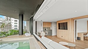 A modern interior with a pool, seating area, and kitchen. - Nodo Hotel (Manizales)