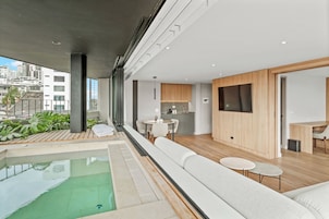 A modern interior with a pool, seating area, and kitchen.