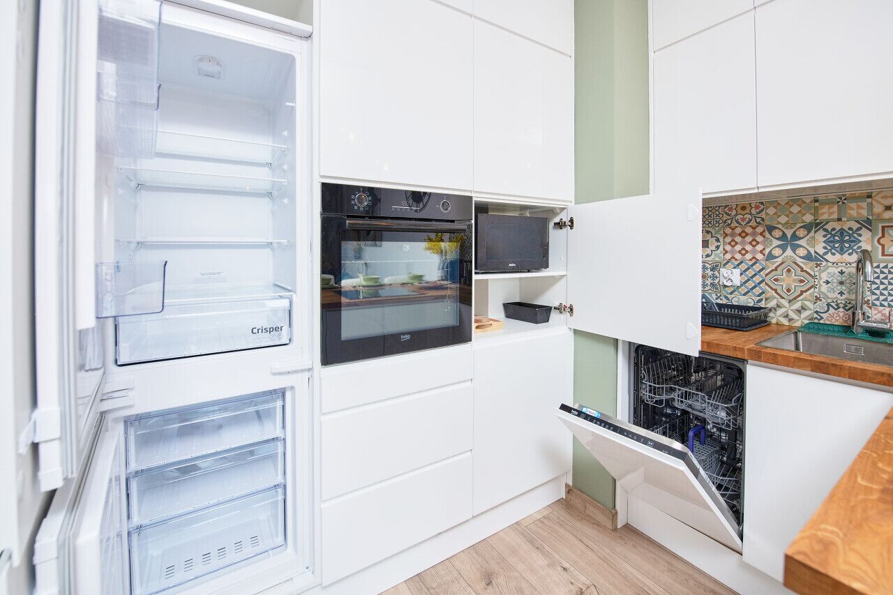 A compact kitchen with a built-in oven, a microwave, and a dishwasher.