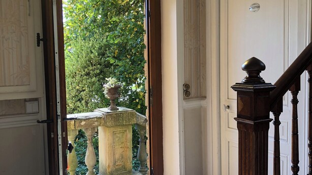 A hallway with a wooden staircase, a white door with a sign, and a view of greenery outside. - Villa Bonne Entente en Ardenne. Château Fort🏰. Nature🍀 Histoire Nautisme Vélo (Donchery)