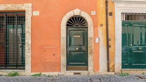A building with numbered doors, a green door, and a barred window. - Domus Beato Angelico |  two minutes from the Pantheon and Piazza della Minerva (Roma)