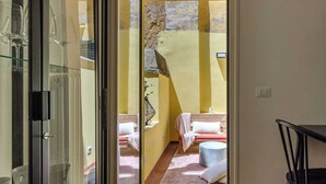 A room with a glass door leading to a balcony, a sofa, a round table, and a chair. - Domus Beato Angelico |  two minutes from the Pantheon and Piazza della Minerva (Roma)