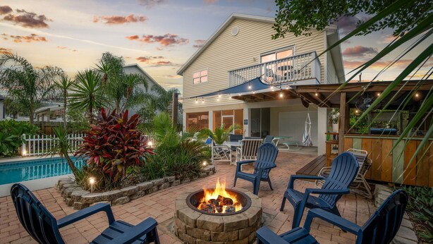 A patio with a fire pit, outdoor seating, and a pool. - Heated Pool, Spa & Tiki Bar! Full Garage Game Room and Steps Away From The Beach (St. Augustine)