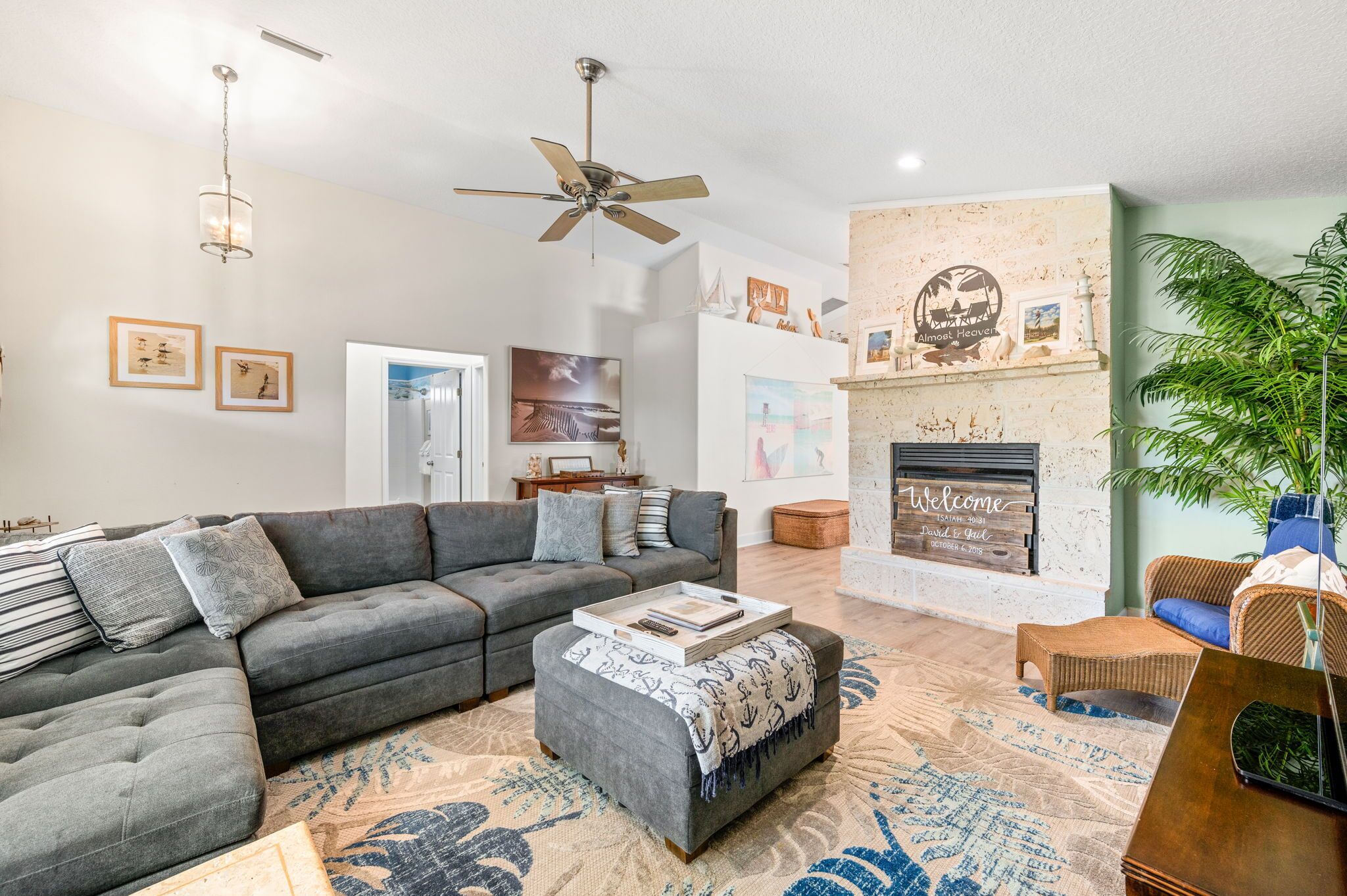 A living room with a sectional sofa, ottoman, and a fireplace.