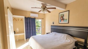 A bedroom with a bed, a ceiling fan, a framed picture on the wall, and a view of the outdoors. - Villa Bugambilias Near Bacalar Lagoon (Bacalar)