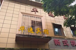 A building facade with a tiled exterior and a window with a decorative grille. - Huayi Business Hotel (Wuhan)