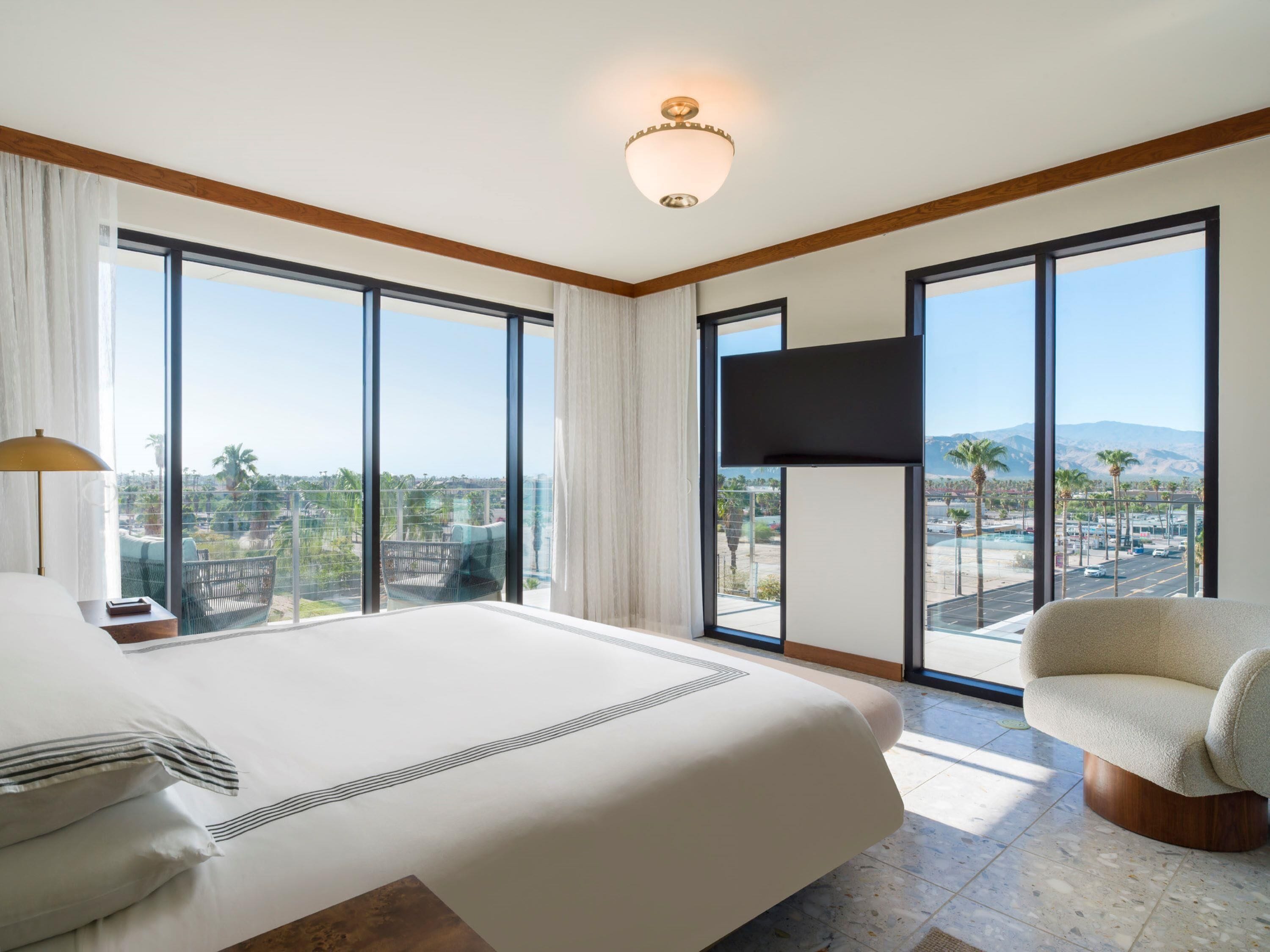 Habitación de hotel con una cama grande, un televisor de pantalla plana y vistas a la ciudad.