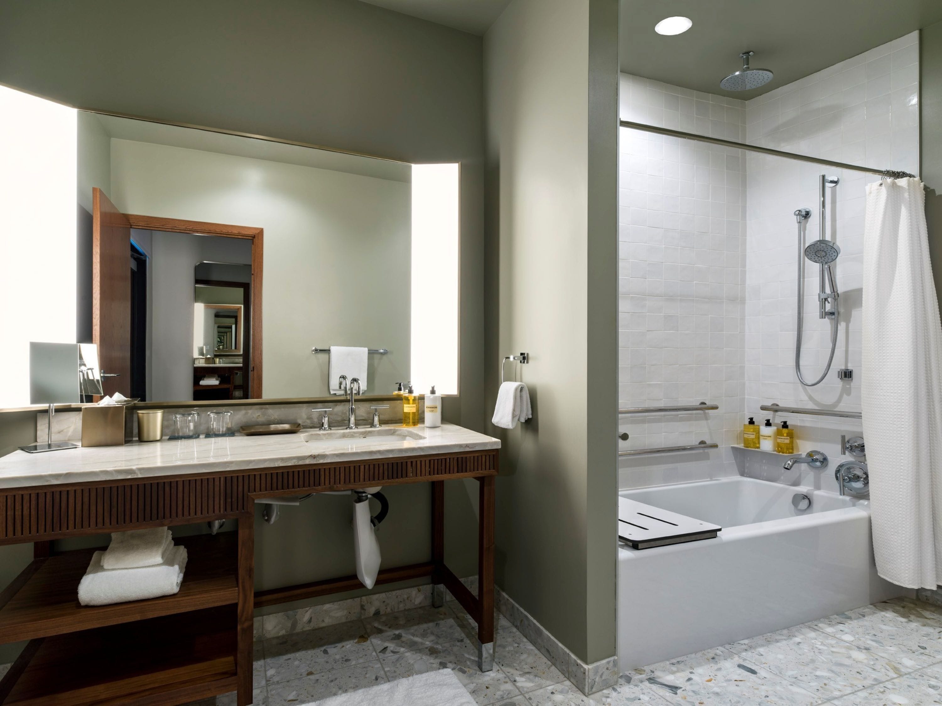 Un baño moderno con lavamanos doble, un espejo grande, ducha con cabezal de ducha manual y bañera.