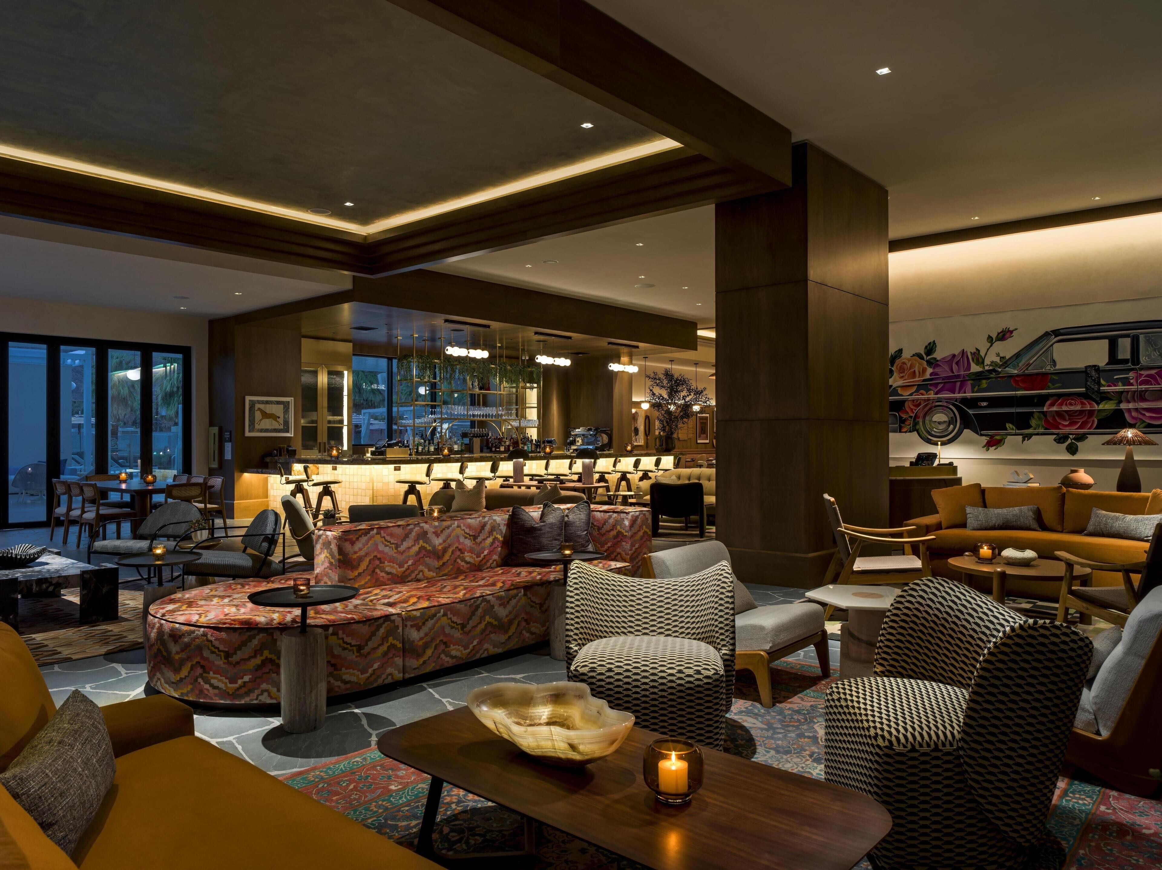 A modern lounge area with seating, a bar, and a large window.