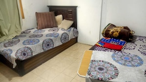 A room with a bed and a small table, both covered with patterned tablecloths. - Egyptian room (Cairo)