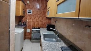 A compact kitchen with a stove, sink, and cabinets. - Egyptian room (Cairo)