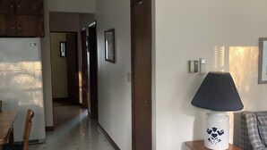 A hallway with a dining area, a sofa, and a lamp. - Charming 2-bedroom cottage in Fish Creek with AC, heat, WiFi (Fish Creek)