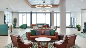 A lobby with a green sofa, two armchairs, a round table, and a patterned floor. - Fairfield By Marriott® Inn & Suites Grovetown (Grovetown)