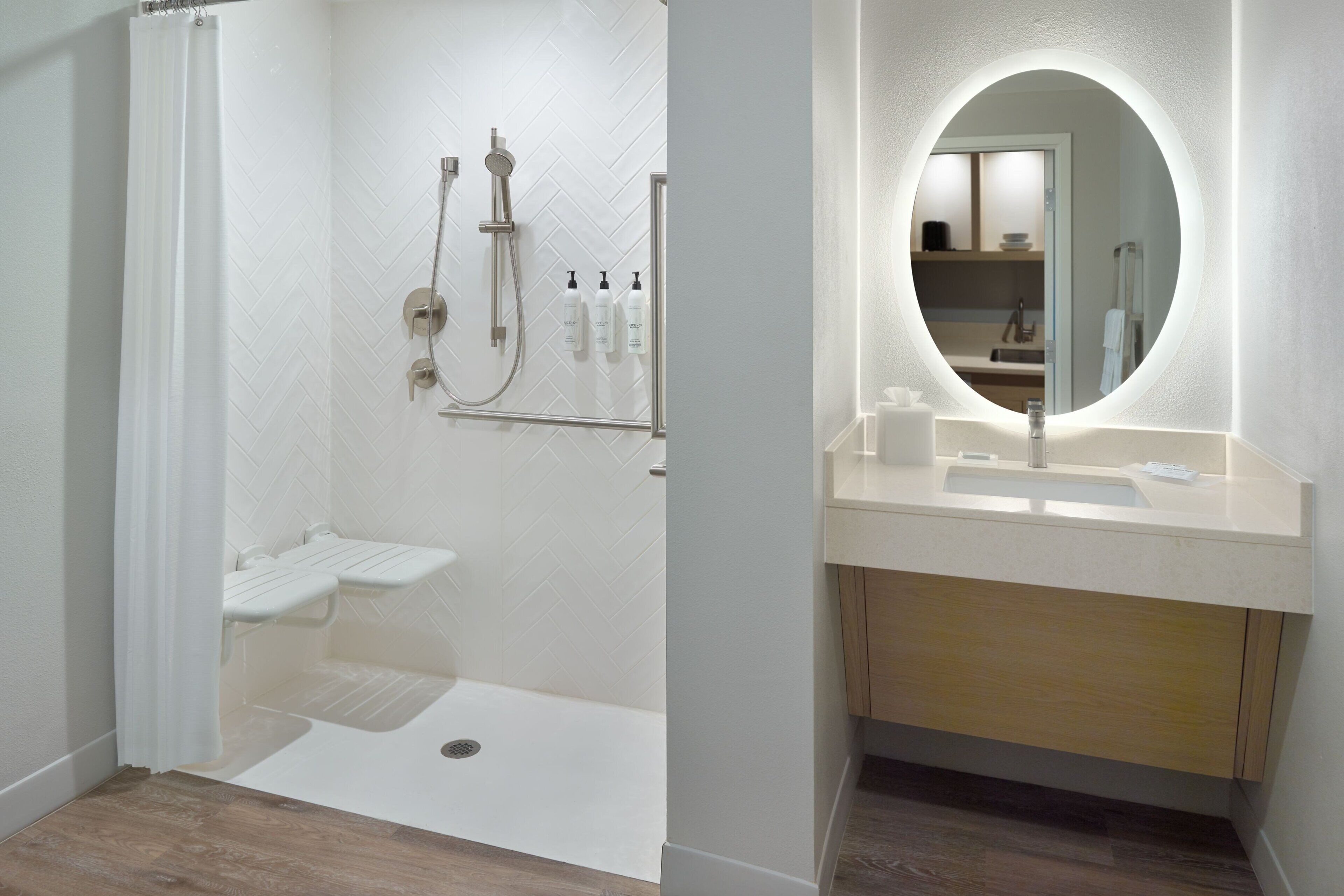 A modern bathroom with a shower, toilet, and sink.