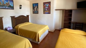 Habitación de hotel con dos camas, cabecero de madera, televisión de pantalla plana y obras de arte en las paredes.