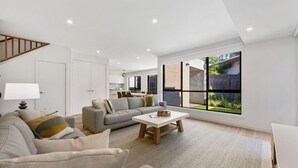 Una sala de estar moderna con sofá, mesa de centro y zona de comedor.