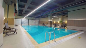 An indoor swimming pool with clear water, surrounded by lounge chairs and a tiled floor. - Best Western Plus Hotel & Residences Istanbul (Istanbul)