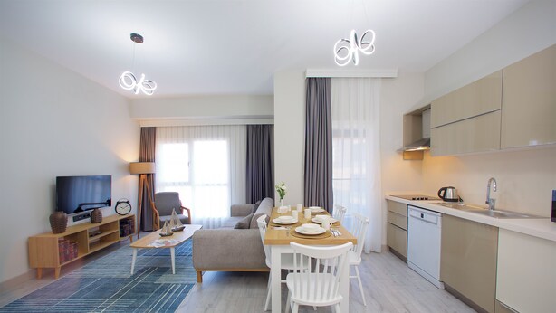 A modern living room with a sofa, TV, and dining area. - Best Western Plus Hotel & Residences Istanbul (Istanbul)