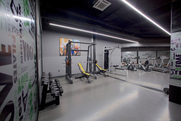 A gym with weightlifting equipment, exercise machines, and a mirrored wall. - Best Western Plus Hotel & Residences Istanbul (Istanbul)