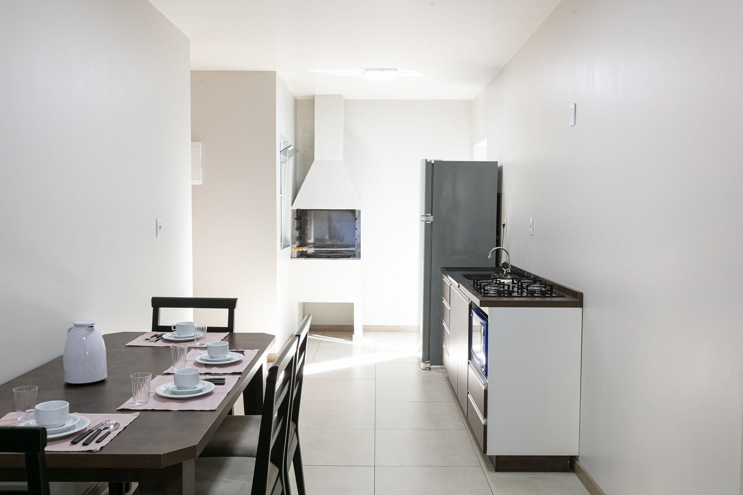 A compact kitchen with a dining area, a built-in oven, and a microwave.