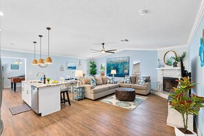 Un espacio habitable amplio con cocina, mesa de comedor y chimenea.