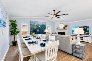 A modern living room with a dining area, a fireplace, and a large window. - Luxurious Spa Retreat with Stunning Pool in Palm Harbor (Palm Harbor)