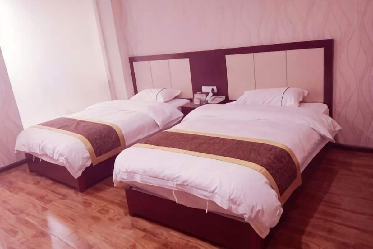 A double bed with a wooden headboard and two bedside tables, each with a lamp.