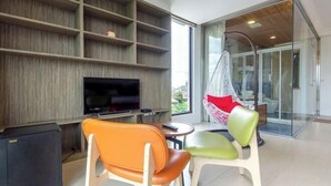 A modern living room with a flat-screen TV, wooden shelving, and two chairs. - Colorful Fish Cottage (Yilan)