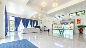 A spacious hotel lobby with a modern design, featuring a reception desk, seating area, and large windows allowing natural light. - Colorful Fish Cottage (Yilan)