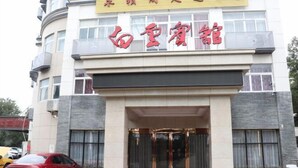 A hotel entrance with a red car parked in front. - Baiyun Hotel (Shaoxing)