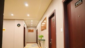 A hotel hallway with a carpeted floor, a sign indicating room number 4F, and a door labeled 8406. - Baiyun Hotel (Shaoxing)