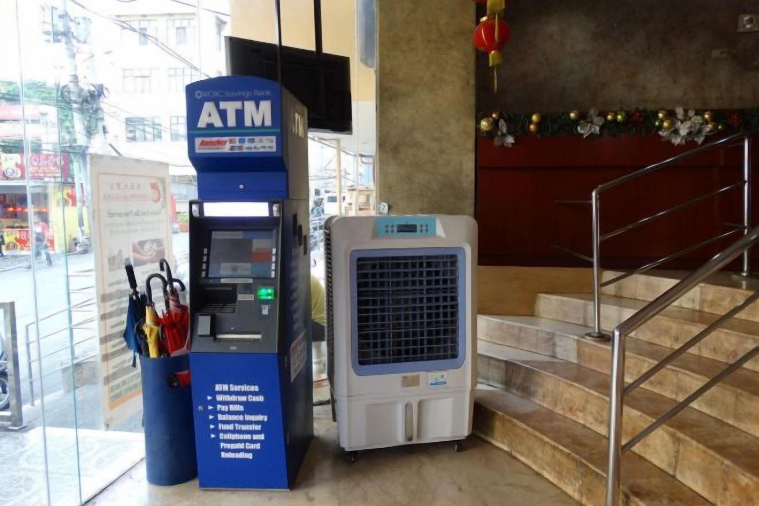 An ATM machine and a portable air conditioner in a public indoor space.